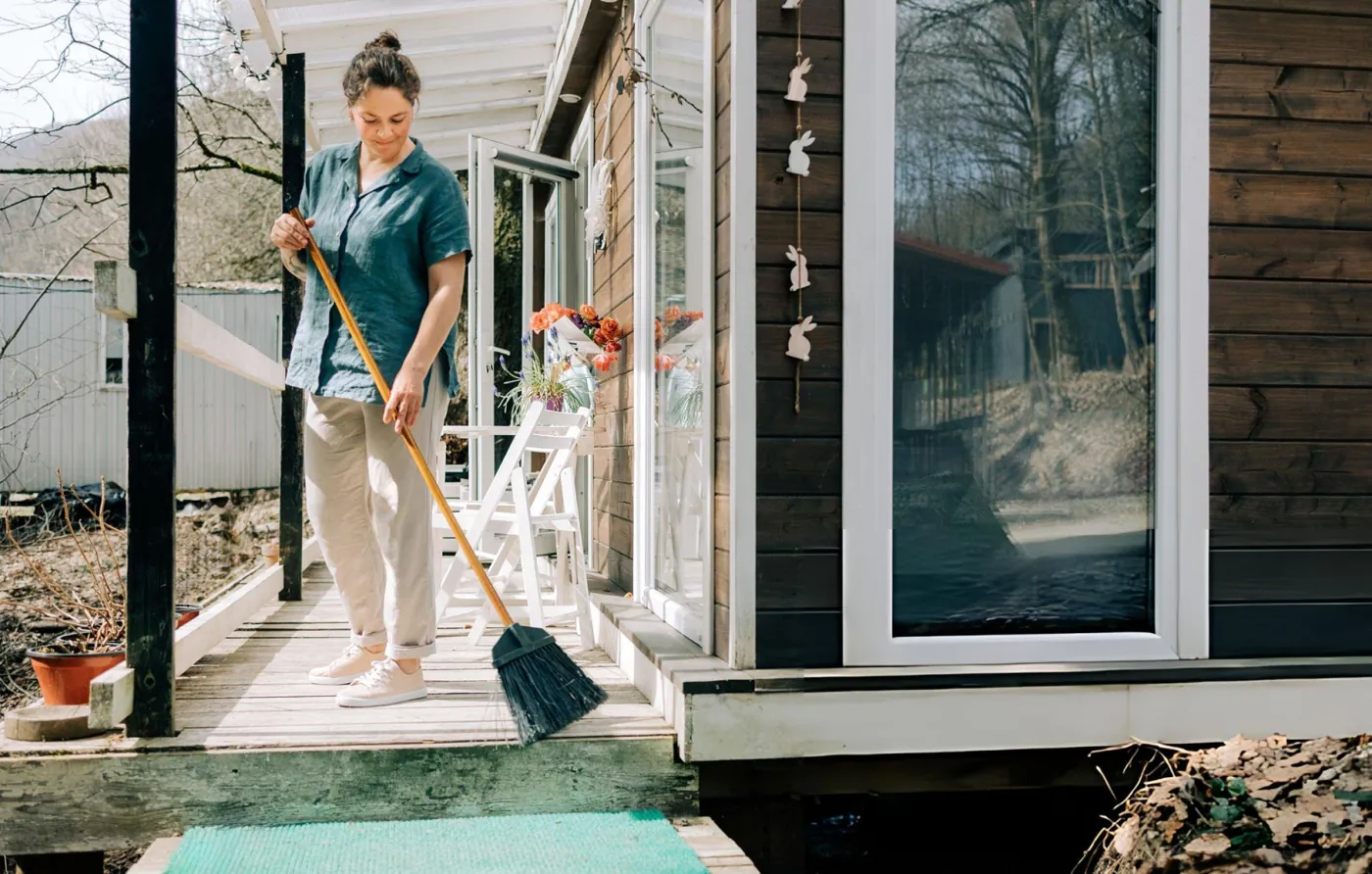 A Shining Services cleaner working outside a home on a bright day